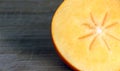 Autumn fruits: half persimmon on a chopping board