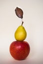 Red apple and little yellow pear with brown leaf
