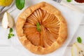 Autumn galette with pear, walnuts, caramel sauce and cinnamon on a white wooden background