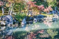 An autumn garden at the Tenryu-Ji Temple in Kyoto Japan with the colors of fall reflecting in the calm water Royalty Free Stock Photo