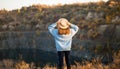 Autumn girl in blue sweater and hat standing backwards and admire nature lake view. Autumn forest colors with girl back view Royalty Free Stock Photo