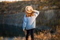 Autumn girl in blue sweater and hat standing backwards and admire nature lake view. Autumn forest colors with girl back view Royalty Free Stock Photo