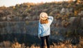 Autumn girl in blue sweater and hat standing backwards and admire nature lake view. Autumn colors with girl back view. Royalty Free Stock Photo