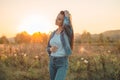 Autumn Girl enjoying nature on the field. Beauty Girl Outdoors raising hands in sunlight rays. Beautiful Teenage Model girl