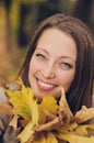 Autumn girl playing in city park. Fall woman portrait of happy lovely and beautiful young woman in forest in fall colors. Royalty Free Stock Photo