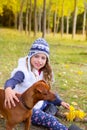 Autumn girl in poplar tree forest playing with dog Royalty Free Stock Photo