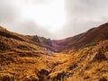 Autumn golden mountain gorge with a road in the distance and sharp teeth of petrified magma. Journey through the country Royalty Free Stock Photo