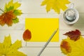 Autumn greeting card. Autumn mood with coffee concept. Frame autumn leaves with yello envelope on wooden background Royalty Free Stock Photo