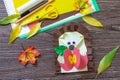 Autumn Greeting postcard hedgehog with an apple on a wooden table. Handmade. Project of children`s creativity, handicrafts, craft. Royalty Free Stock Photo