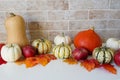 Autumn Halloween or thanksgiving day table setting. Fallen leaves, pumpkins on white wooden table Royalty Free Stock Photo