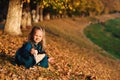 Autumn happy baby girl playing with fallen golden leaves. Happy carefree childhood. Little girl in a blue coat walking at autumn p Royalty Free Stock Photo