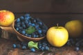 Autumn harvest blue sloe berries and apples on a wooden table ba