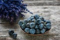 Autumn harvest blue sloe berries on a wooden table with a bouquet of lavender in the background. Copy space. Rustic style.
