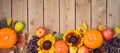 Autumn harvest concept with pumpkin, apples and sunflowers on wooden table. Thanksgiving holiday background. Top view from above Royalty Free Stock Photo