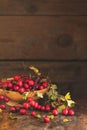 Autumn harvest Hawthorn berry with leaves in bowl on a wooden ta Royalty Free Stock Photo