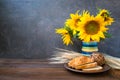 Autumn harvest, natural products, Greeting card concept. Still life with beautiful sunflowers in vase, sliced white bread on clay Royalty Free Stock Photo