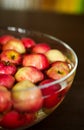 Red apples taking a bath in glass bowl fill with water.