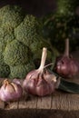 Autumn harvest still life. Close view brocolli garlic rustic wooden desk Royalty Free Stock Photo