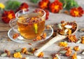 Autumn healing background. Folk medicine Glass of herbal tea with marigold flowers on wooden ancient background with dried flowers Royalty Free Stock Photo