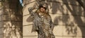 Autumn High Fashion.Stylish model wearing fashionable autumn winter outfit with leopard print walks on sunny autumn day in the