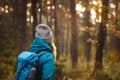 Woman with backpack and knit hat looking at woodland Royalty Free Stock Photo