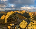 Autumn hiking in the mountains with massive rocks, dramatic skies and majestic mountains.