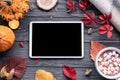 Autumn holiday background with tablet computer screen mock up on wooden table