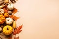 Autumn holiday composition with pumpkins, nuts and dry leaves on paper beige color background. Fall harvest, Halloween,