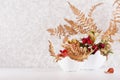 Autumn home decor with dried fern leaf, berries and leaves rose hip and ripe red hawthorn in bowl on soft light white wood table. Royalty Free Stock Photo