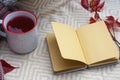 Autumn, home decor in the style of the Scandinavian Hygge. Fruit tea, red chrysanthemum and a notepad