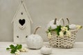 Autumn home decoration with birdhouse, white pumpkins and snow berry branches