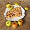 Autumn homemade apple pie - charlotte. on white ceramic plate on wooden background with fresh apples Royalty Free Stock Photo