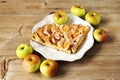 Autumn homemade apple pie - charlotte. on white ceramic plate on wooden background with fresh apples Royalty Free Stock Photo