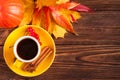 Autumn horizontal banner with yellow, red leaves, pumpkins, cup of coffee and guelder rose on brown wooden background. Royalty Free Stock Photo