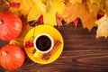 Autumn horizontal banner with yellow, red leaves, pumpkins, cup of coffee and guelder rose on brown wooden background. Concept for Royalty Free Stock Photo