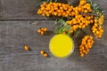 Autumn hot drink. Tea with sea-buckthorn berries branch on vintage wooden background. Space for your text Royalty Free Stock Photo