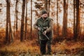 Autumn hunting season, hunter with rifle looking out for some wild animal in the wood or forest, outdoor sports concept Royalty Free Stock Photo