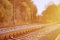 Autumn industrial landscape. Railway receding into the distance among green and yellow autumn tree