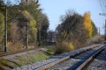 Autumn industrial landscape. Railway receding into the distance among green and yellow autumn tree
