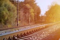 Autumn industrial landscape. Railway receding into the distance among green and yellow autumn tree