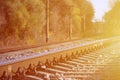 Autumn industrial landscape. Railway receding into the distance among green and yellow autumn tree