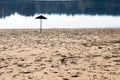 Lake beach without people and lonely umbrella on the edge