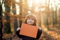 Autumn kids advertising and sale. Cute child showing blank placard with copy space for your text. Little boy holding Royalty Free Stock Photo