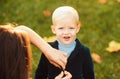 Autumn kids, lovely child playing with fallen leaves in autumn park. Happy childhood concept. Royalty Free Stock Photo