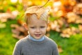 Autumn kids, lovely child playing with fallen leaves in autumn park. Fall leaves children concept, autumnal mood.