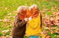 Autumn kiss. Friendly romantic boys and girls enjoy autumn day in park, childhood lifestyle concept. Kids love. Royalty Free Stock Photo