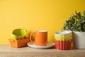 Autumn kitchen interior background with plant, colorful bowls and coffee cup on wooden shelf