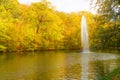 Autumn lake landscape view, fountain and yellow trees