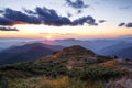 Autumn landscape. Amazing sunset enlightens surroundings. From the lawn in orange grass, a panoramic view of the high mountain,