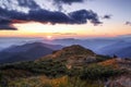 Autumn landscape. Amazing sunset enlightens surroundings. From the lawn in orange grass, a panoramic view of the high mountain,